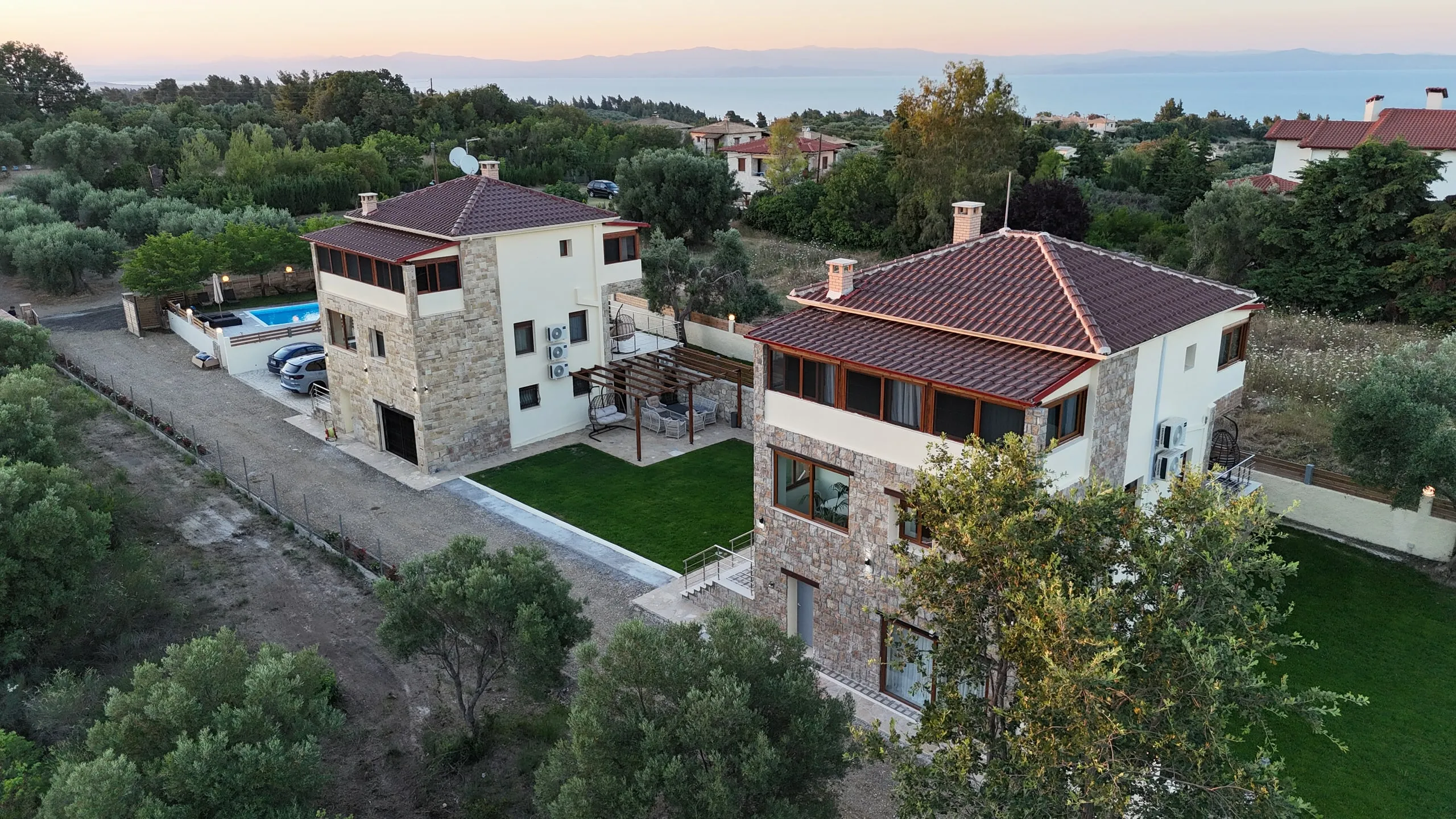 Villen mit Pool, Kryopigi, Chalkidiki, Griechenland — Pergola und Naturstein am Abend