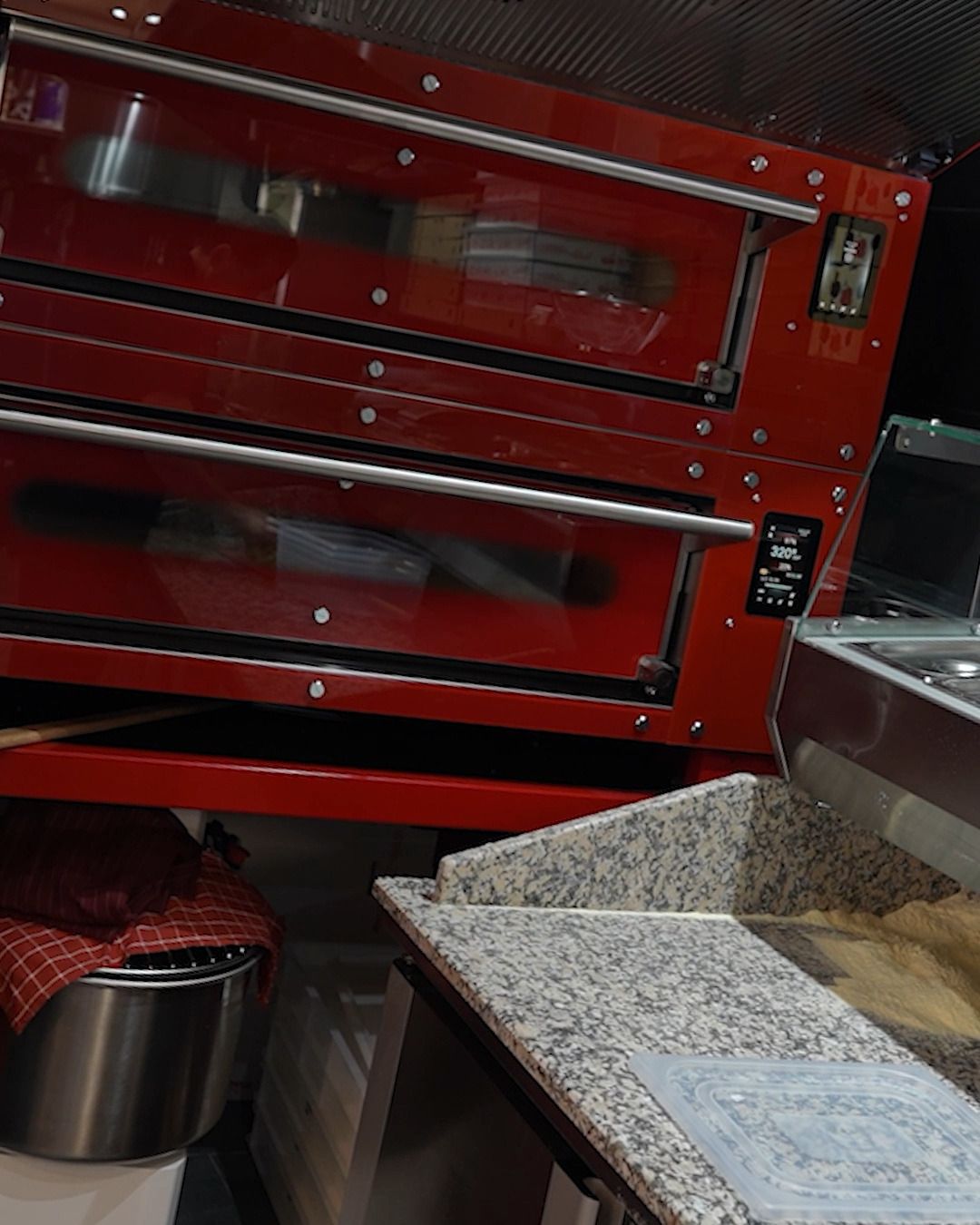 Restaurant with glazed terrace, Lausen BL — Kitchen: deck pizza oven, granite worktop (Still from video)